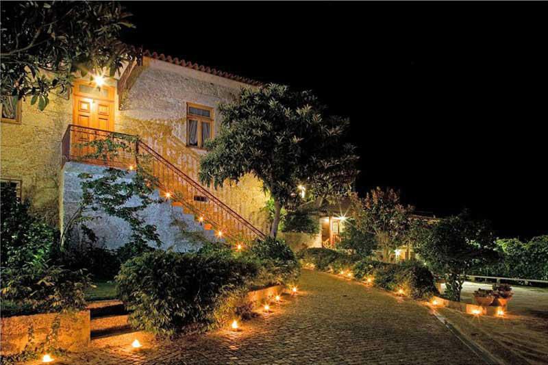 Festas Privadas — quinta iluminada à noite com velas no caminho